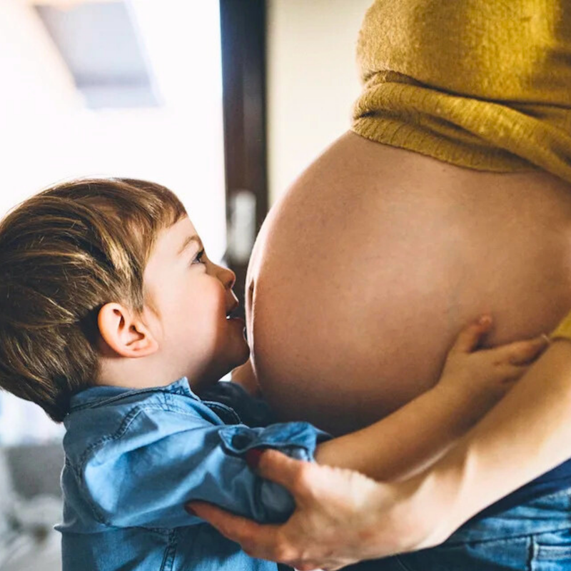 boy hugging pregnant belly
